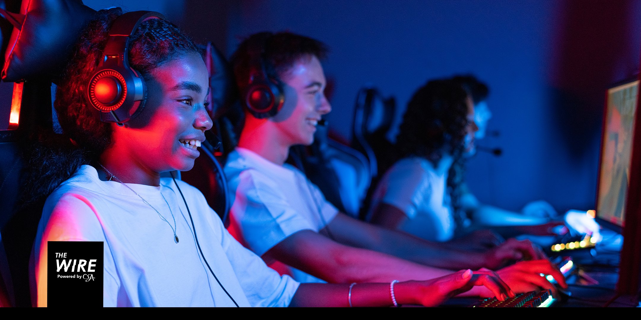 Young gamers in an esports arena, lit in neon - where youth culture and commerce now meet